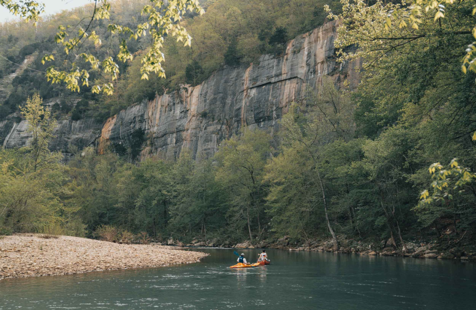 Two Canoers on river near shore.